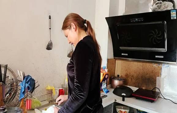 在铜仁市碧江区响塘龙社区，搬迁户田国霞在厨房切柚子（5月8日摄）。 新华社记者 肖艳 摄